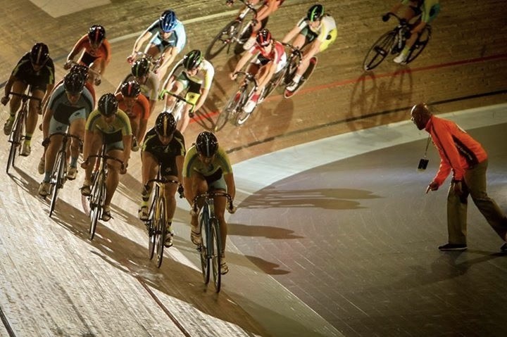 Peter coaching trackside as a pack of riders sweeps through the banking